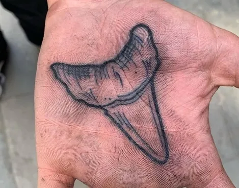 shark tooth tattoo on palm idea